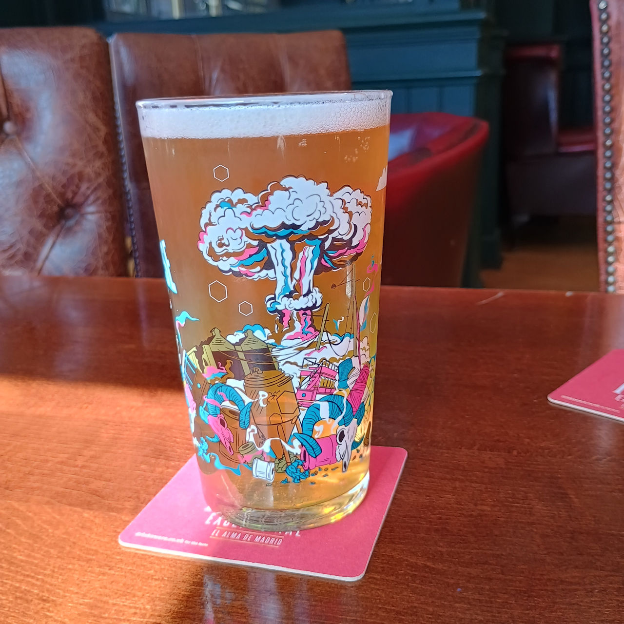 A full glass of Alpacalypse, showing a stylised mushroom cloud, and assorted debris.